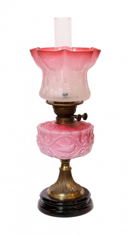 A late Victorian brass and pink opaque glass oil lamp with tinted frosted shade