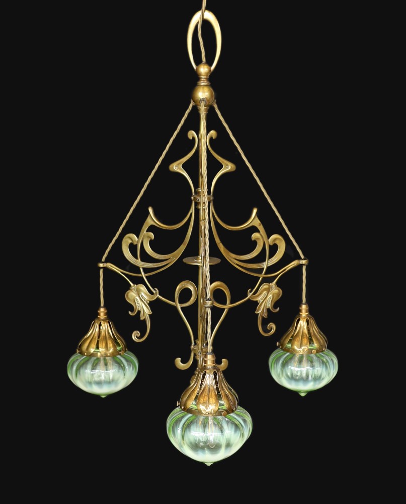 An English Arts & Crafts brass light fitting with scrolling foliate branches and tinted iridescent glass shades