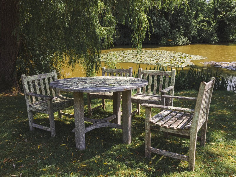 Wooden table and chairs in garden setting Wooden table and chairs in garden setting