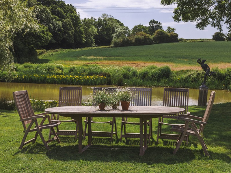 Wooden table with six chairs in garden setting Wooden table with six chairs in garden setting
