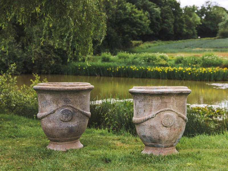 Two stone urns in garden setting Two stone urns in garden setting