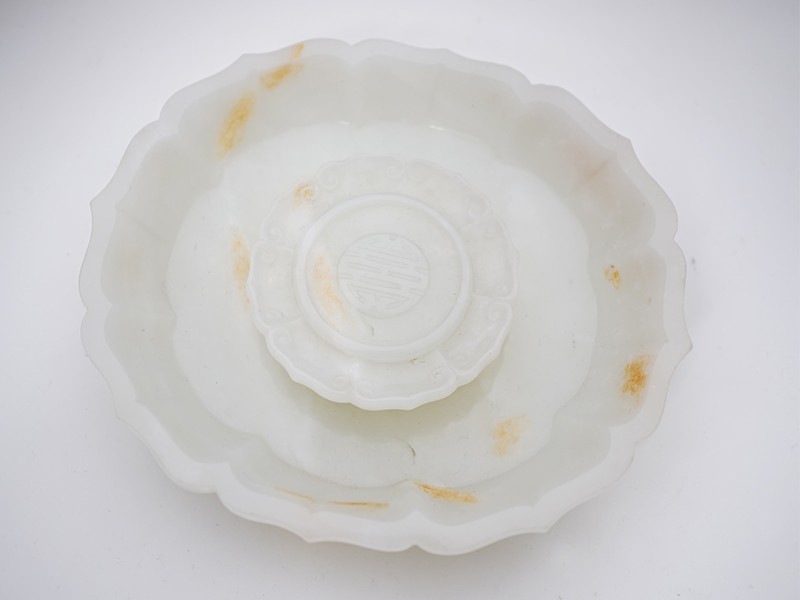 A Chinese white and russet jade petal lobed cup stand A Chinese white and russet jade petal lobed cup stand